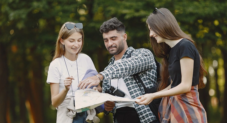 Young adults planning hike with map outdoors