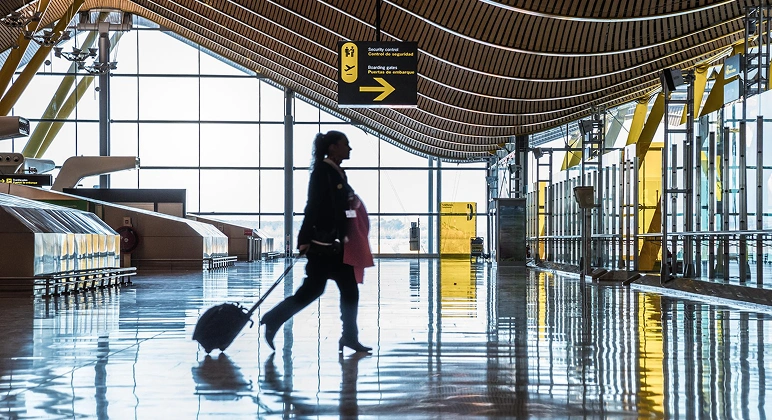 Traveler with luggage at airport terminal