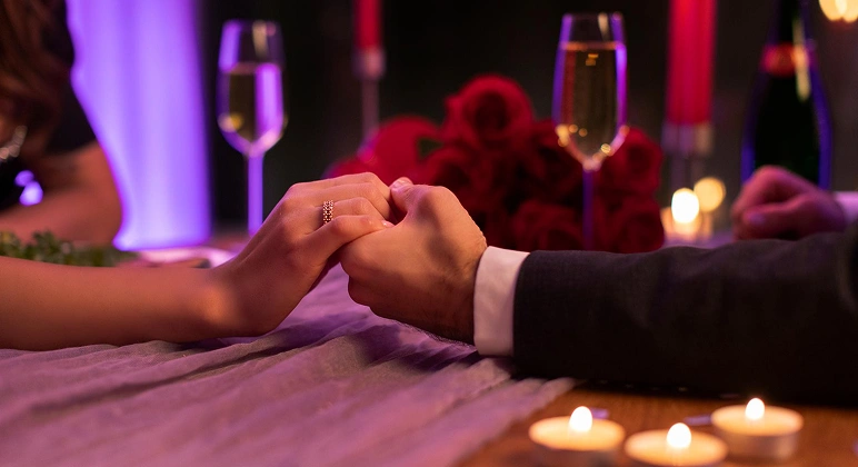 Couple holding hands with engagement ring